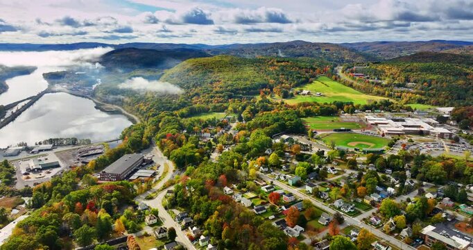 Flight above the beautiful scenery of Vermont, New England, USA. Amazing autumn nature near the lake. Dramatic clouds hang over the rocks at backdrop.