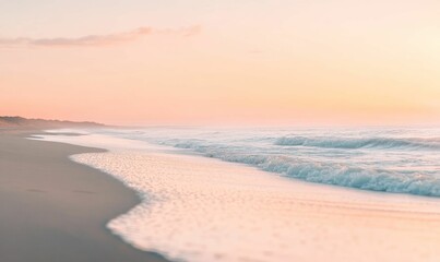 Sandy beach with gentle waves and a pink sky.
