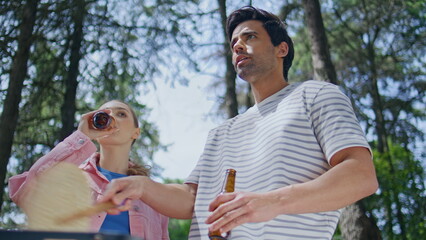 Smiling couple cooking picnic grilling food in forest closeup. Happy woman man