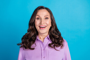 Fototapeta premium Photo of cheerful excited lady dressed puple blouse smiling empty space isolated blue color background