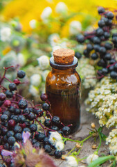 Flower and herbal extract in a bottle. Selective focus.