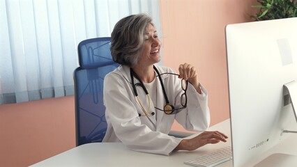Doctor, middle-aged Caucasian woman with short gray hair, wearing white coat, stethoscope, glasses...