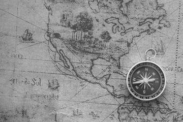 Classic round compass on background of old vintage map of world