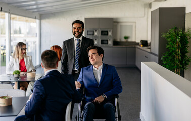 Business team greeting new partner in wheelchair