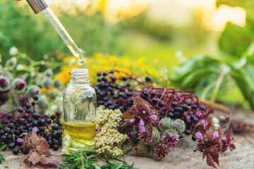 Flower and herbal extract in a bottle. Selective focus.