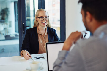 Business people, man and woman in meeting, laptop and conversation with planning, research and review. Employees, mentor and coaching with computer, brainstorming and teamwork with cooperation or joy