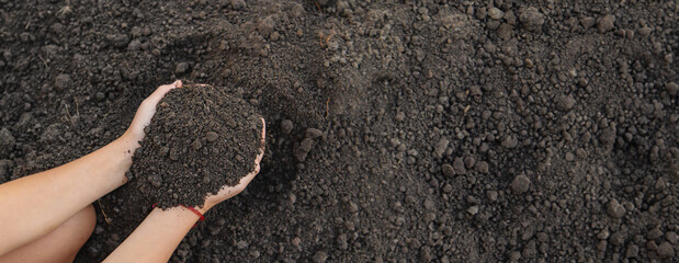 A child holds soil in his hands. Selective focus.