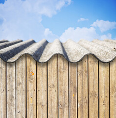 Old aged roof made of corrugated asbestos panels - dangerous materials in buildings and...