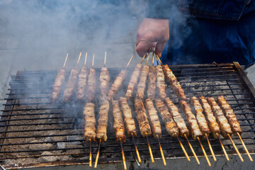 A grill filled with skewers of meat cooking