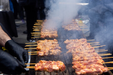 A grill filled with skewers of meat cooking