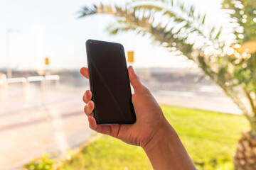 Girl holds a smartphone with a black screen close-up. Phone on the background of the airport with an airplane