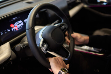 The interior of a modern car features a sleek steering wheel and a sophisticated digital display