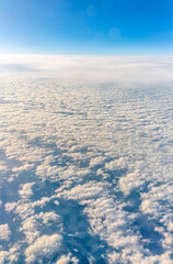 View from the airplane window at a beautiful cloudy sky and the airplane wing