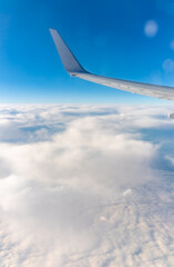 View from the airplane window at a beautiful cloudy sky and the airplane wing