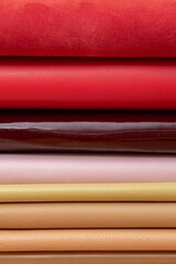 Stacked colorful leather fabrics with diverse textures.