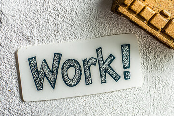 Motivational message card saying work on a textured surface