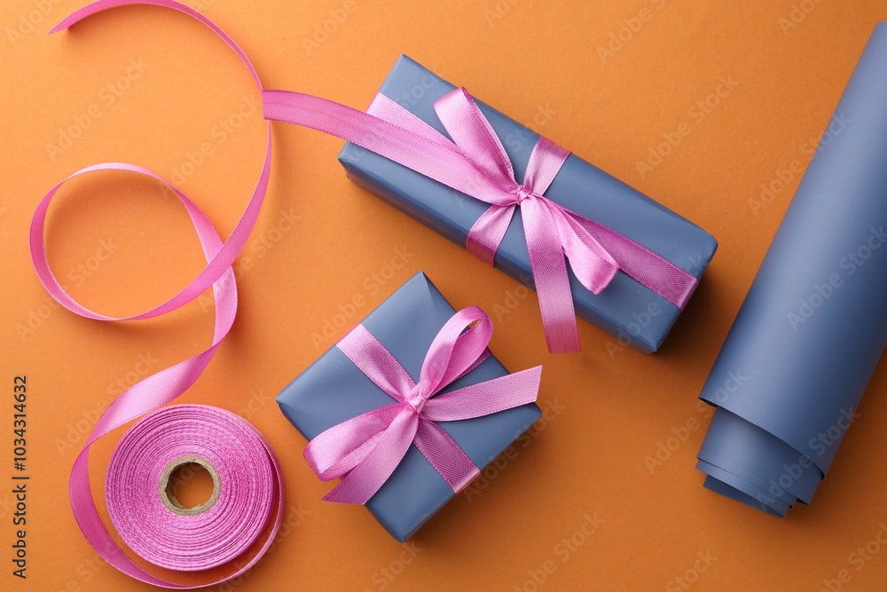 Sticker Beautiful gift boxes with pink bows, ribbon and roll of wrapping paper on orange background, flat lay