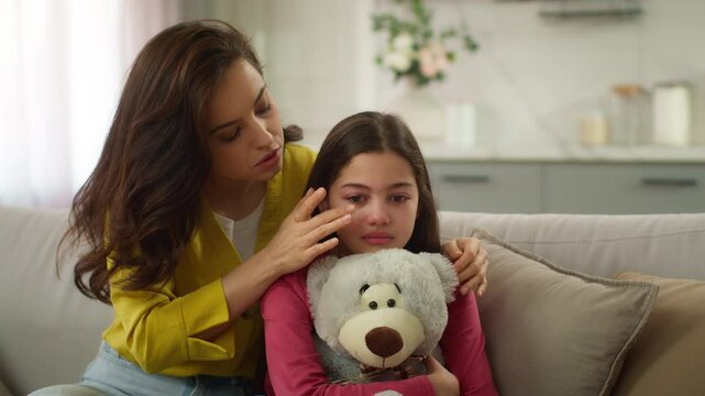 Worried Caucasian parent woman feel guilty female mother apologizing ask forgiveness little girl after quarrel argument calming sad child hugging saying sorry to crying kid daughter indoor living room