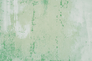 Textured green plaster wall surface with peeling paint. Aged, weathered concrete background