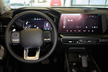 Closeup of a modern car steering wheel with control buttons for technology and convenience