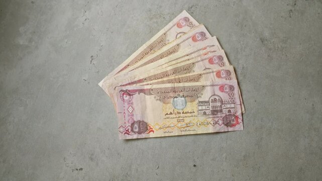 United arab emirates dirhams laid out on a smooth concrete surface showcasing currency and financial themes