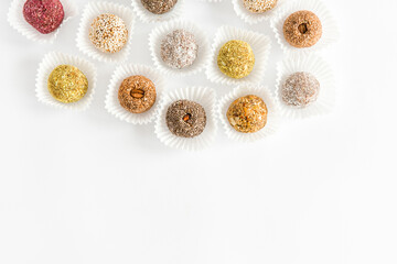 Box of healthy sweets, candies made from natural ingredients. Vegetarian organic food. White background, top view, copy space