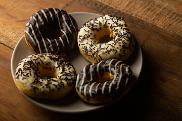 Donuts in chocolate glaze on the table on a plate for Hanukkah