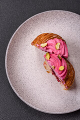 Sweet craffin or panettone garnished with raspberry and pistachio flavored cream