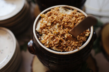 Large clay ceramic jar filled with homemade lard. Rustic country-style table in a traditional restaurant. Rural dining background. Meat pork lard.