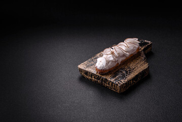 Sweet eclair with custard decorated with coconut slices