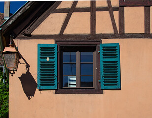 Abstract view facade of vintage house with window with open wooden shutters and street lantern....