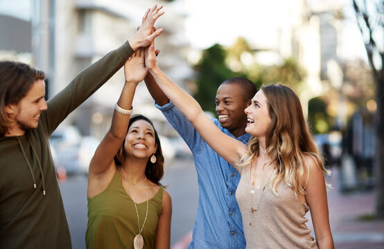 Happy people, friends and city with hands together for motivation, unity or teamwork on sidewalk. Young, group or community solidarity with huddle for mission, collaboration or synergy in urban town