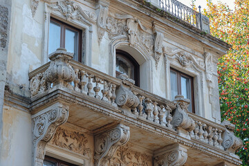 Obraz premium Ornate balcony details on historic building in vibrant garden setting