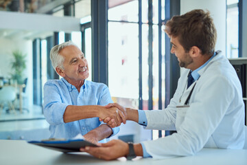 Senior man, handshake and doctor with documents for insurance, policy or medical application at...