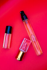 Bottles for fragrances. Red Background. Women's perfume, fragrant oil with Place for your text