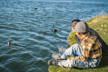 two latin children brothers looking at the ducks on a lake la paz bolivia - concept of nature