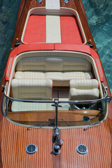 Exclusive expensive wooden boat Riva Aquarama on azure water, top view. Detail of the front of the Riva boat, aerial view. Front of a boat with an American flag Riva Aquarama top view.