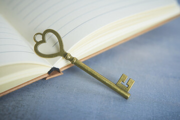 Antique Heart-Shaped Key Resting on Open Notebook