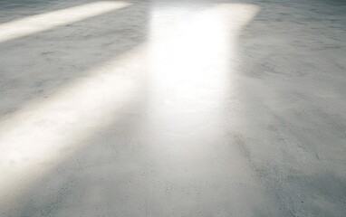 Bright sunlight filters through large windows onto a polished concrete floor in a spacious interior during late afternoon