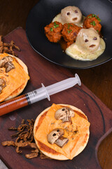 halloween idea funny and horrifying dishes two mini pizza with skull and mushroom with sauce in a syringe cupcake ghost meat top view