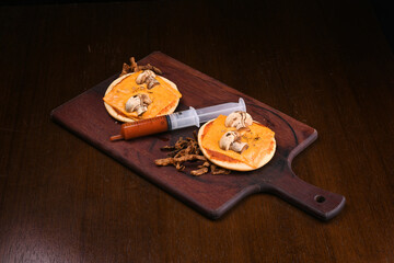 halloween idea funny and horrifying dishes two mini pizza with skull and mushroom with sauce in a syringe top view crispy onion