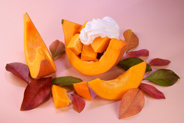 fresh whole pumpkin, pieces of pumpkin on a background of autumn leaves. Autumn background.