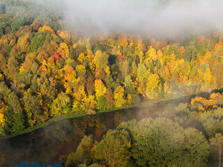 Autumn forest and river through the clouds