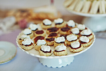 Food, catering and scones on table at tea party, event or thanksgiving celebration at home. Snacks, dessert and cream pastry closeup at buffet for hospitality, gathering and bakery sweets background