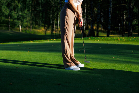 Golf player on professional golf course. Golfer with golf club taking a shot