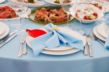 Festive table setting. Glasses, plates, cutlery, snacks, napkins