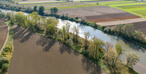 Aerial view of a peaceful river surrounded by lush green trees and farmland, showcasing the beauty of nature and agricultural landscapes.