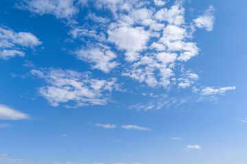 A clear blue sky with fluffy white clouds, perfect for backgrounds or nature themes.