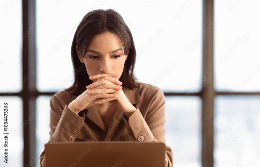 Aufkleber problem solving. focused european businesswoman working on laptop at office, thinking about difficul