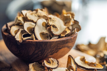 Dried porcini mushrooms. Sliced boletus in bowl on cutting board.